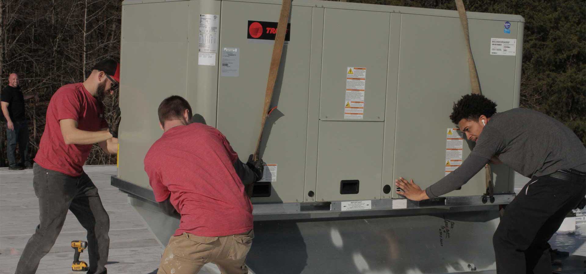 The Five Star Power Systems team setting a commercial HVAC unit on a rooftop curb adapter