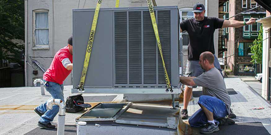 Five Star Power Systems' technicians installing a commercial roof top AC unit