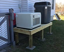 A RS17A air cooled home generator set on an elevated platform next to the home AC unit