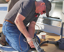 Five Star Power Systems founder, Ken Kloster wiring a commercial air conditioning unit in Hanover, MD