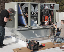 HVAC technicians busily installing a new commercial air conditioning unit